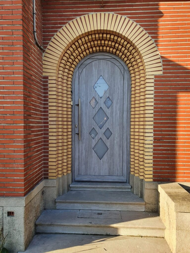 Porte d'entrée cintrée ton chêne grisé à vitrages en losanges