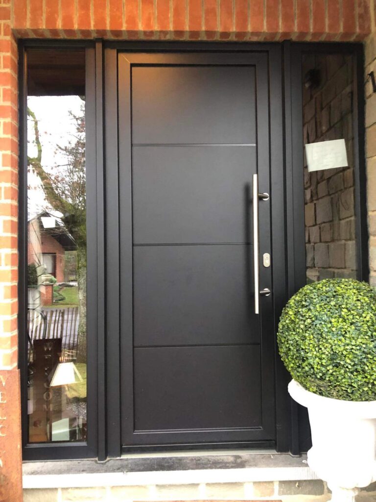 Porte d'entrée noire PVC à rainures horizontales encadrée de deux fixes vitrés, avec longue poignée barre inox