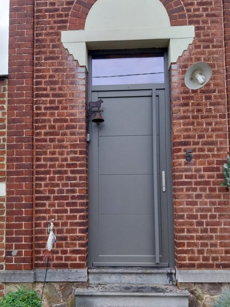 Porte d'entrée gris taupe en bois à rainures horizontales avec imposte vitrée et poignée barre inox