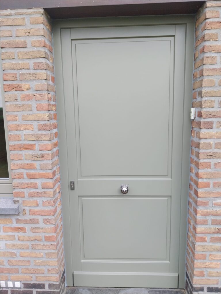 Porte d'entrée vert sauge en bois à deux panneaux moulurés avec bouton de tirage inox central